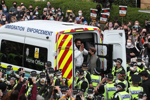 One of two men are released from the back of an Immigration Enforcement van accompanied by Mohammad Asif, director of the Afghan Human Rights Foundation, in Kenmure Street, Glasgow which is surrounded by protesters. (Image: Andrew Milligan/PA Wire)