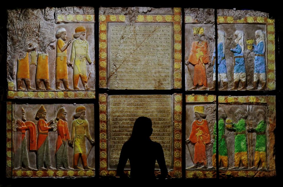 A V&A employee looks at colour images projected onto casts on loan from the British Museum, based on originals from the Palace of Darius, on display at Epic Iran, an exhibition soon to open at the V&A in London, Britain, May 25, 2021. REUTERS/Peter Nicholls