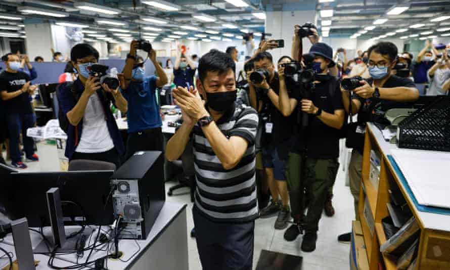 Lam Man-chung, executive editor-in-chief of Apple Daily, applauds colleagues on the paper’s last day. Photograph: Lam Yik/Reuters