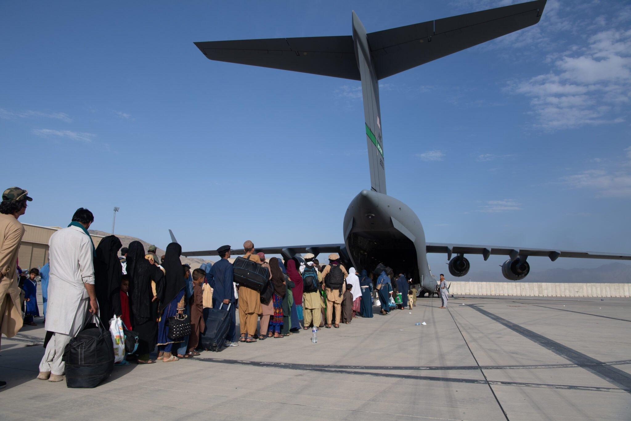 US airmen load passengers aboard a U.S. Air Force C-17 at Hamid Karzai International Airport in Afghanistan. (US Air Force/Master Sgt. Donald R. Allen)