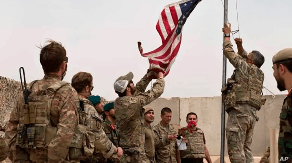 A U.S. flag is lowered as American and Afghan soldiers attend a handover ceremony from the U.S. Army to the Afghan National Army, at Camp Anthonic, in Helmand province, southern Afghanistan, May 2, 2021.