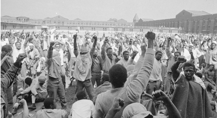 FILE — In this Sept. 1971 file photo, Inmates at the Attica Correctional Facility, in Attica, NY, raise their hands in clenched fists in a show of unity during the Attica uprising, which took the lives of 43 people. Fifty years after the Attica prison uprising, the families of slain and injured prison guards say they're still waiting for an apology from the state. (AP Photo/Bob Schutz, File)