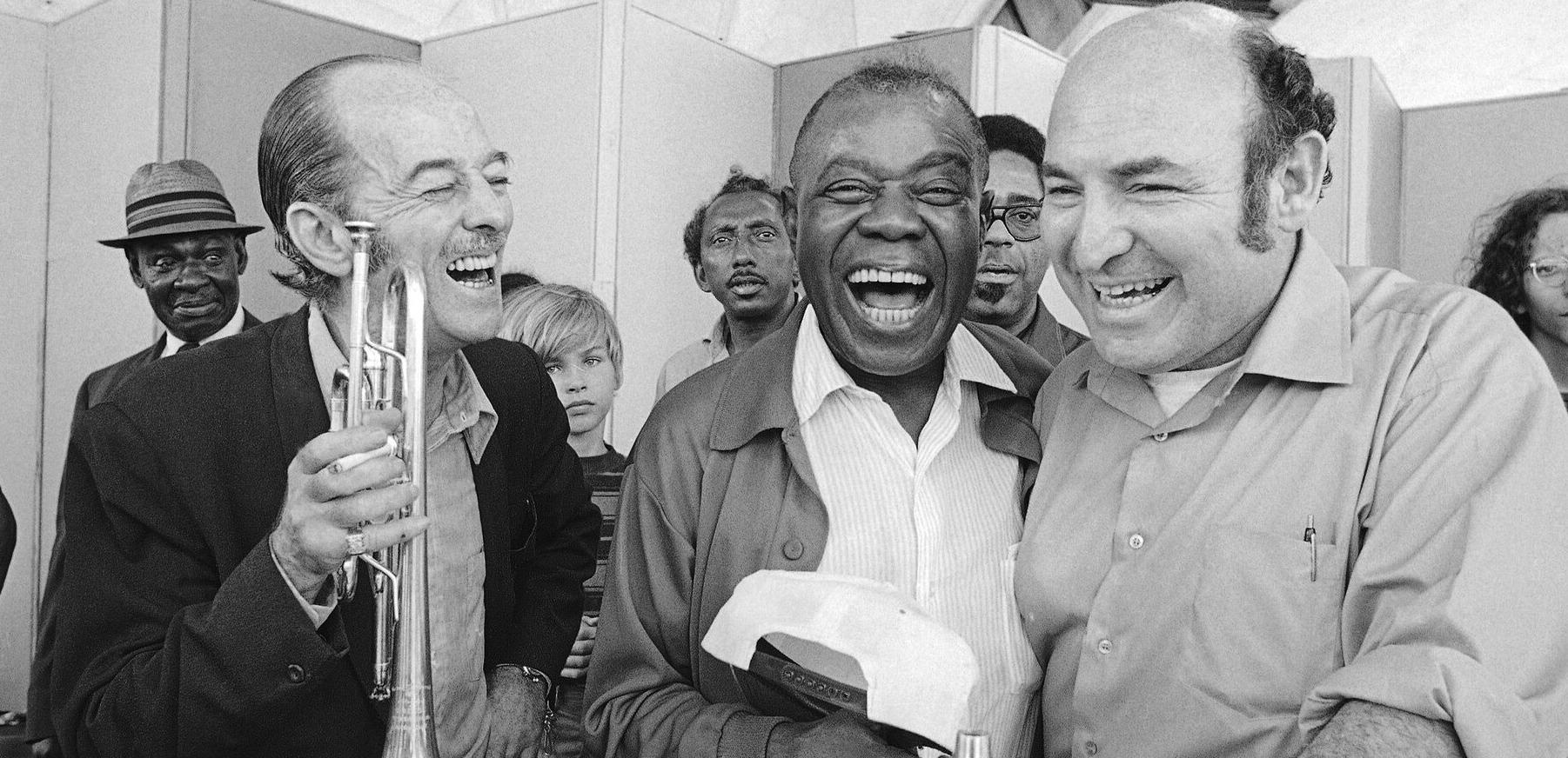 George Wein, right, with the trumpeter Bobby Hackett and Louis Armstrong at the Newport Jazz Festival in 1970. The festival, which Mr. Wein first presented in 1954, became a model for how to present music in the open air on a grand scale.Credit...J Walter Green/Associated Press