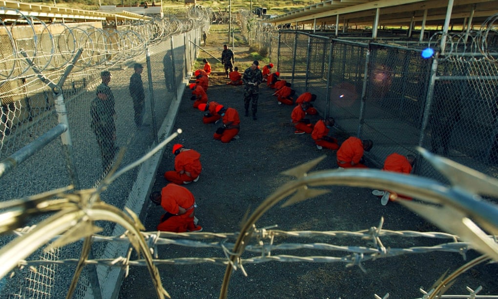 Photo: Detainees at Camp X-Ray, Guantánamo Bay on 11 January 2002. Photograph: Shane T McCoy/PA