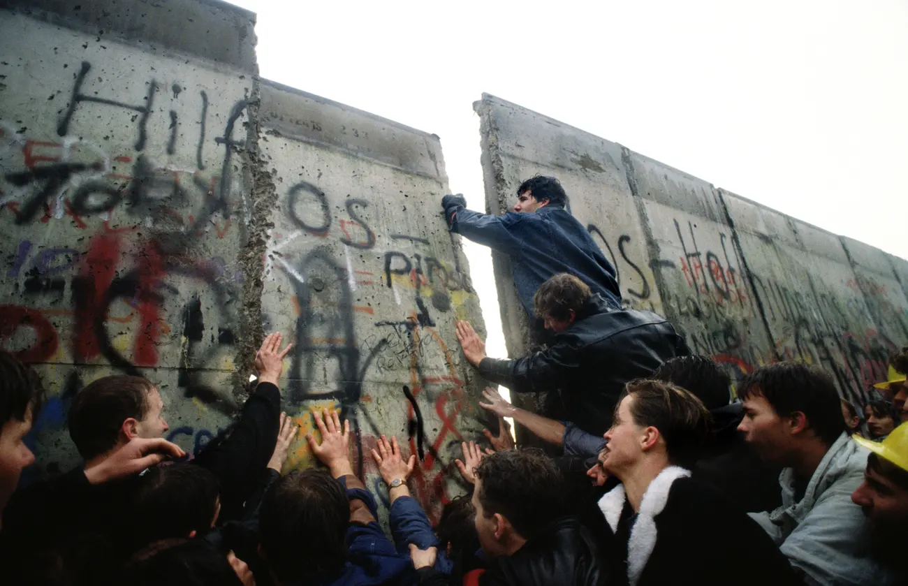 The first section of the Berlin Wall is pushed down by crowds, November 1989. Photograph: Tom Stoddart/Getty Images