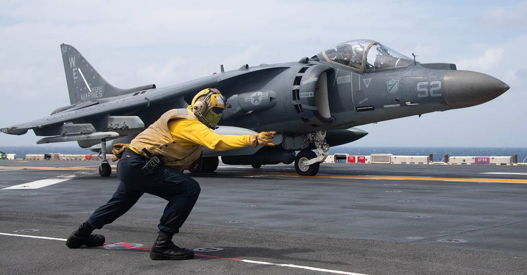 Aviation Boatswain’s Mate 3rd Class Alissa Sanchez signals to an AV-8B Harrier on the flight deck of the amphibious assault ship Essex. (MC2 Wesley Richardson/U.S. Navy)