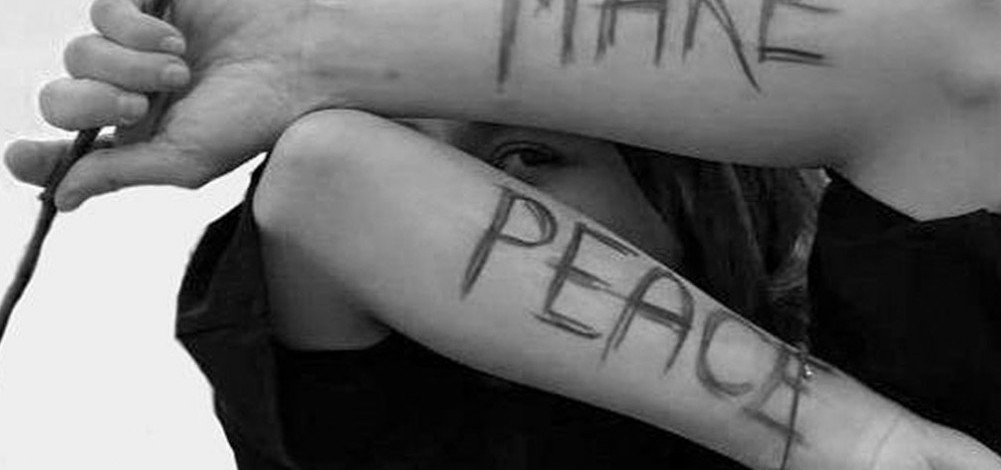 Woman with make peace written on her arms